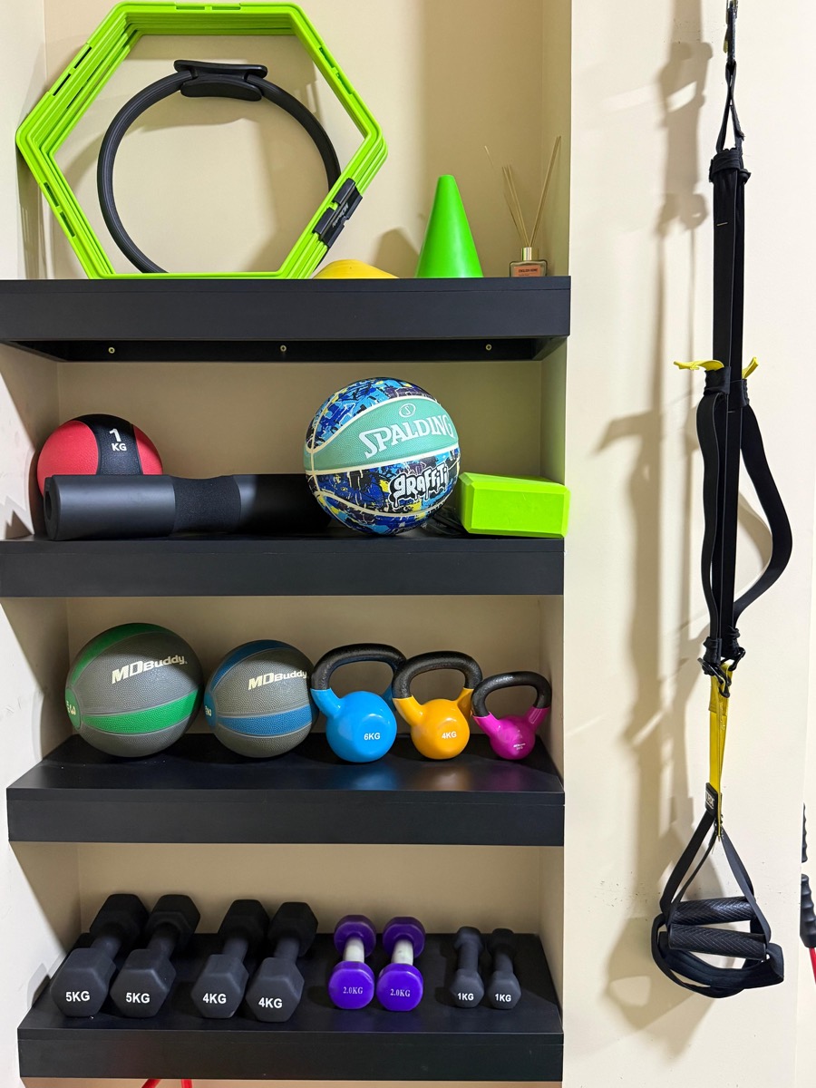 Shelves of kettlebells, dumbbells, medicine balls and a suspension trainer